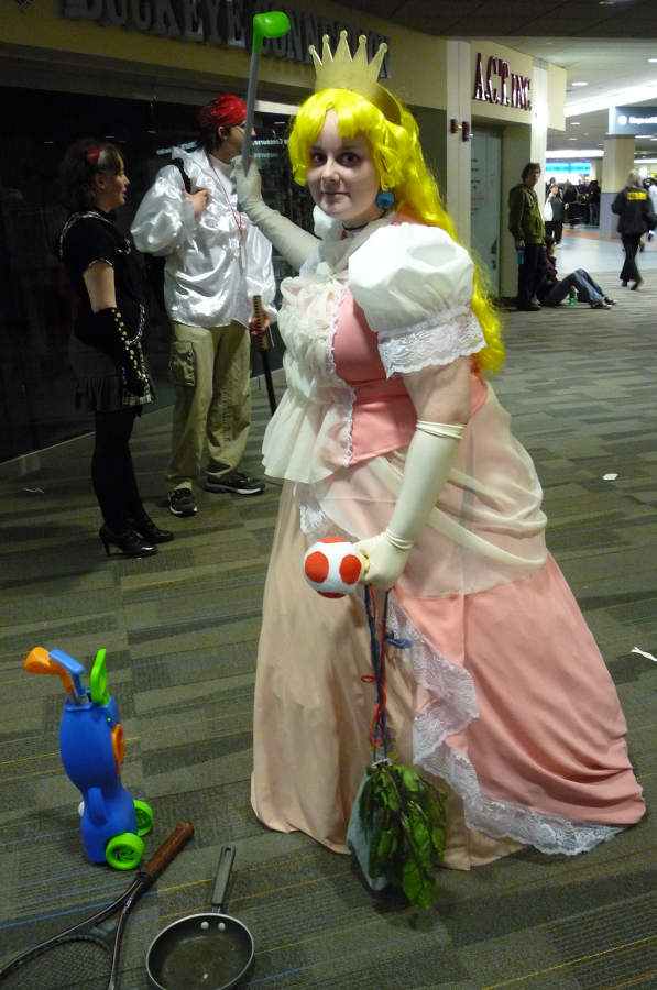 A Princess Peach cosplayer brandishing a golf club at Ohayocon 2010